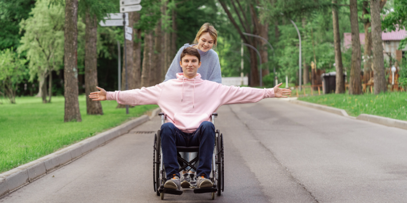 Woman pushing man in a wheelchair